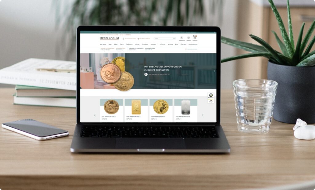 Laptop zeigt Münzwebsite auf Schreibtisch mit Pflanze